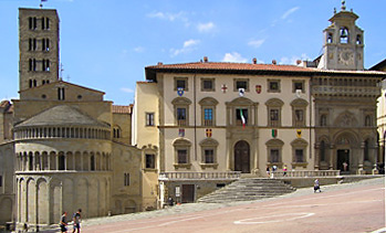 Lato nord-ovest della Piazza Grande: Esterno dell'abside di Santa Maria della Pieve (sx), Palazzo dei tribunali e Palazzo della Fraternita dei Laici (dx, più scuro)